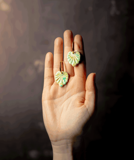 Mint Green Shell Earrings with gold-tone hoops and handcrafted polymer clay charms displayed on a hand