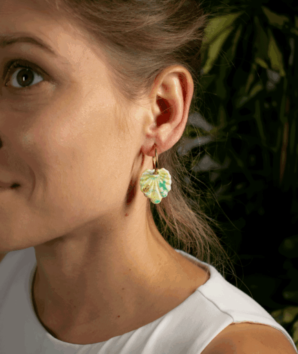 Woman wearing Mint Green Shell Earrings with textured polymer clay pendants and gold-tone hoops
