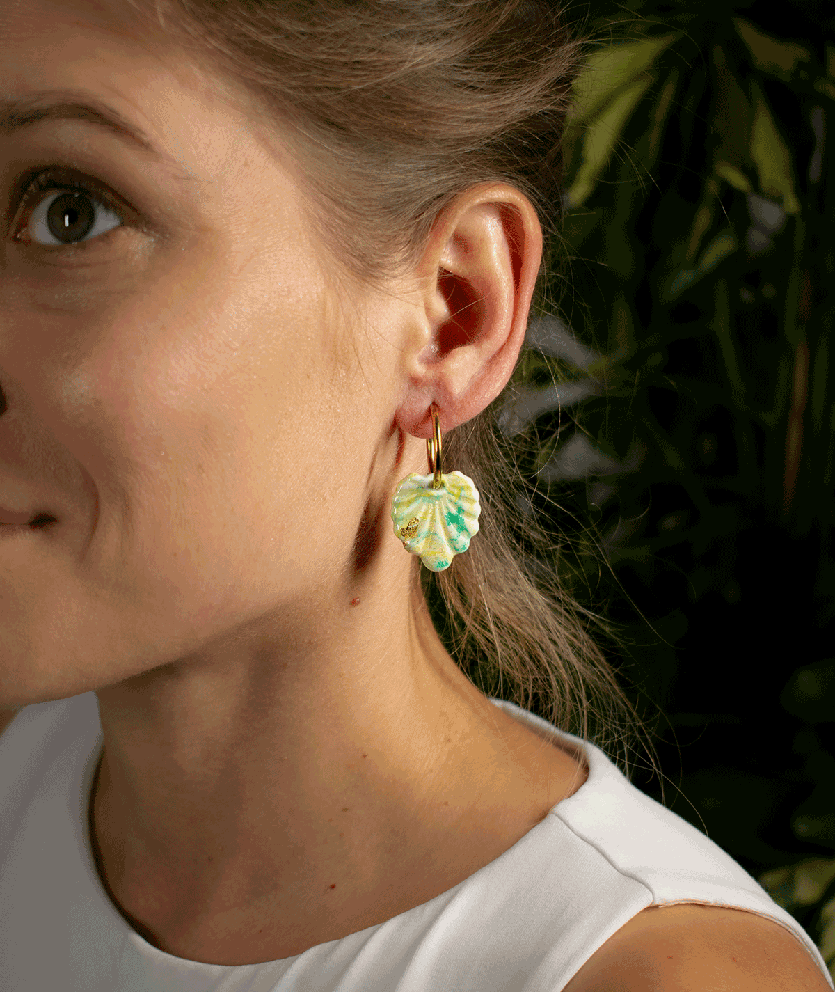 charm_08_b Woman wearing Mint Green Shell Earrings with textured polymer clay pendants and gold-tone hoops