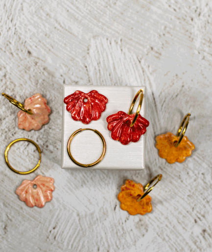 red shell hoop earrings displayed with handmade polymer clay shell earrings in peach pink and orange