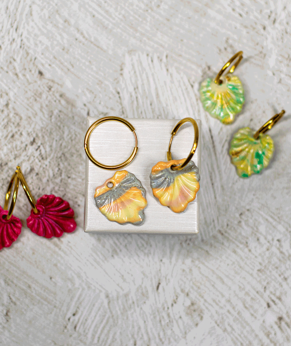 charm_13_c Pastel Shell Earrings by Suzy Decor with marbled peach, cream and grey-blue shell charms on a white display stand