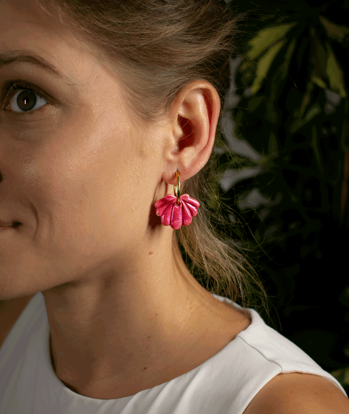 charm_15_b woman wearing raspberry shell hoop earrings with sculpted pink seashell charms and gold-tone hoops