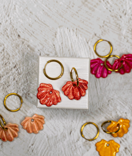 terracotta shell hoop earrings displayed with handmade polymer clay shell earrings in raspberry pink, peach and golden yellow