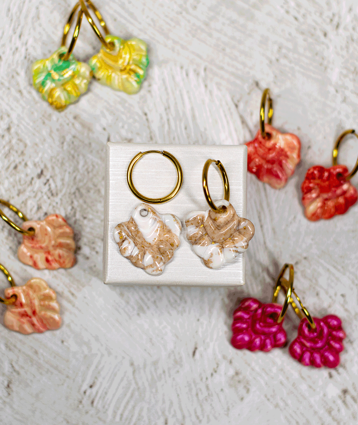charm_20_c2 beige coral hoop earrings displayed with handmade polymer clay earrings in mint green, coral red, peach and fuchsia pink