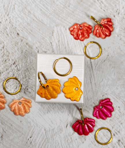 yellow shell hoop earrings displayed with handmade polymer clay seashell earrings in coral red, peach and raspberry pink