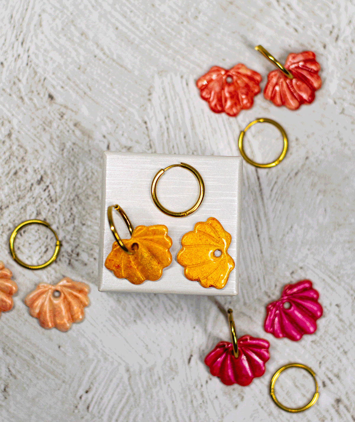 charm_21_c2 yellow shell hoop earrings displayed with handmade polymer clay seashell earrings in coral red, peach and raspberry pink